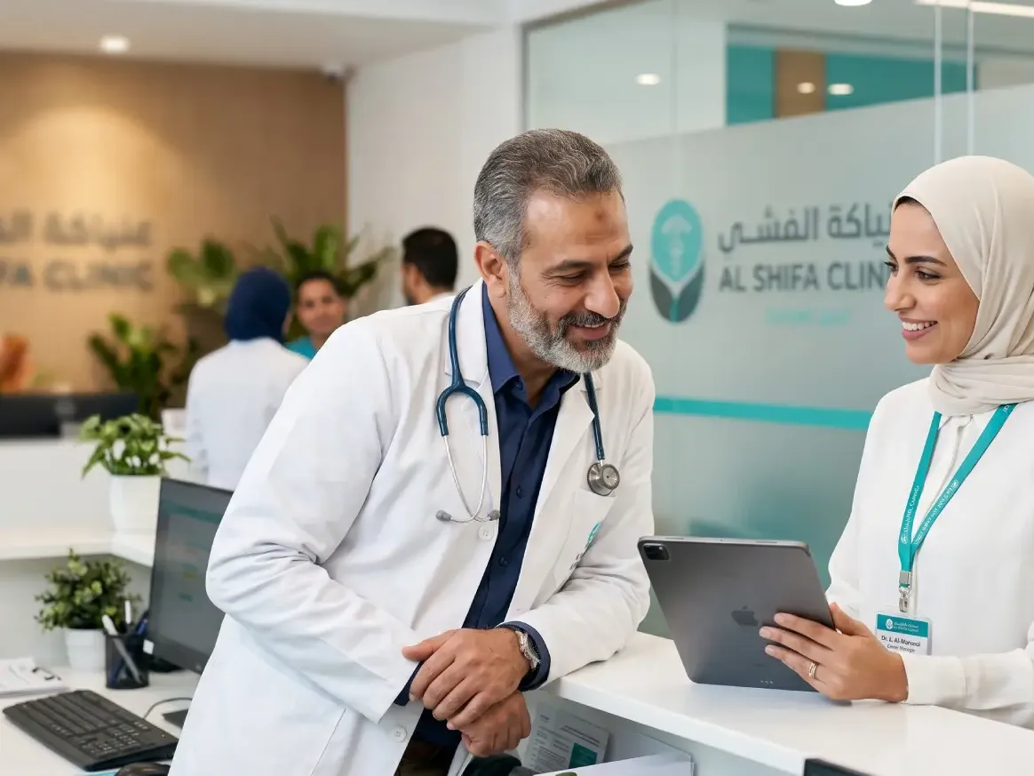 A medical center manager and a senior clinician reviewing a tablet together at a bright modern clinic reception.